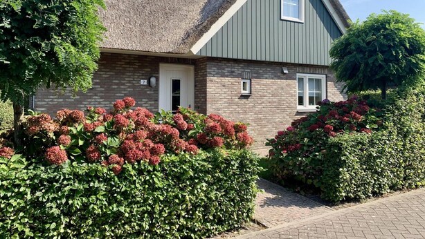 A house with a steeply pitched roof, a brick facade, and a small window. - 6-person Holiday Home With Garden (Sint Maartensvlotbrug)