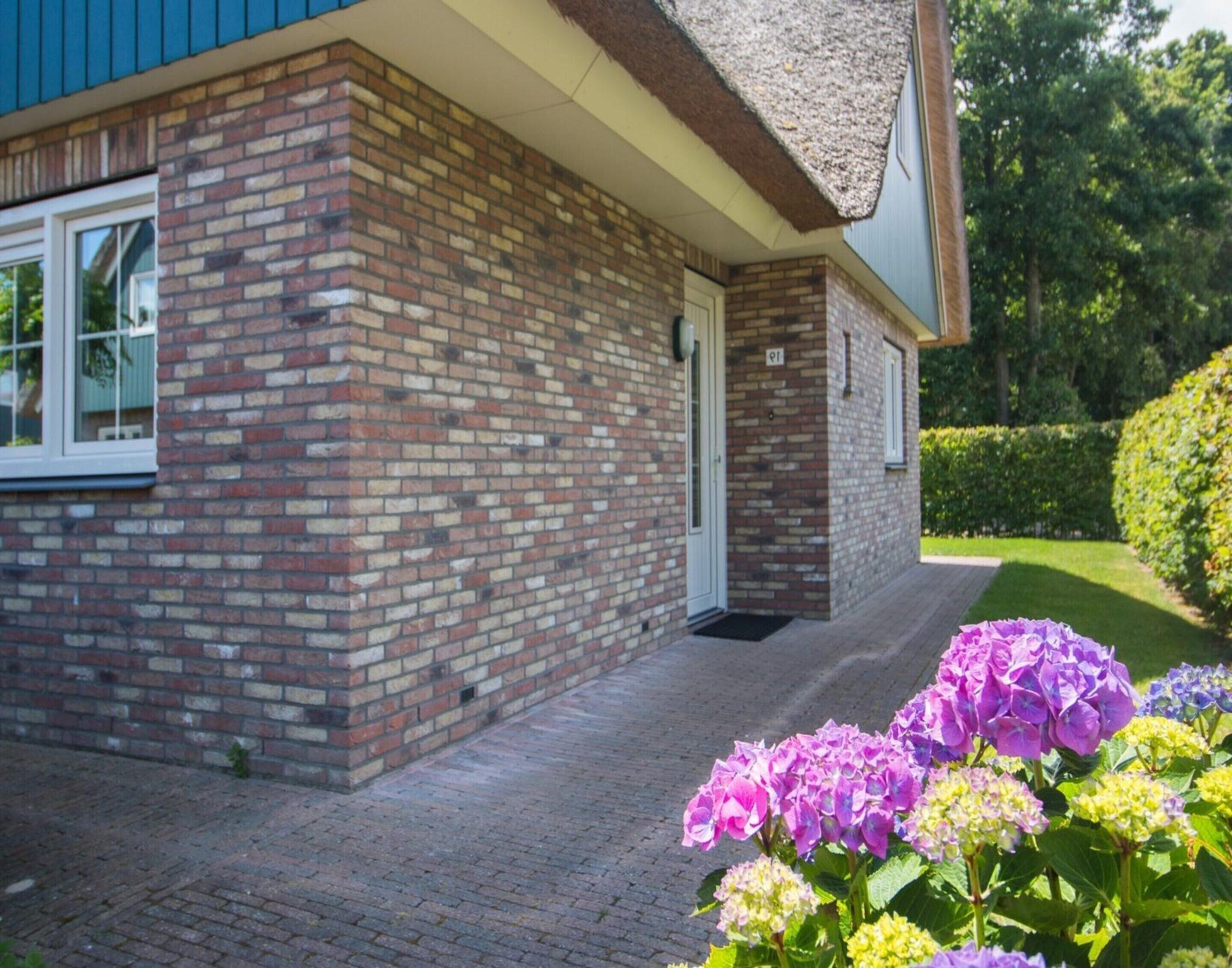 A brick house with a white door and a small porch.