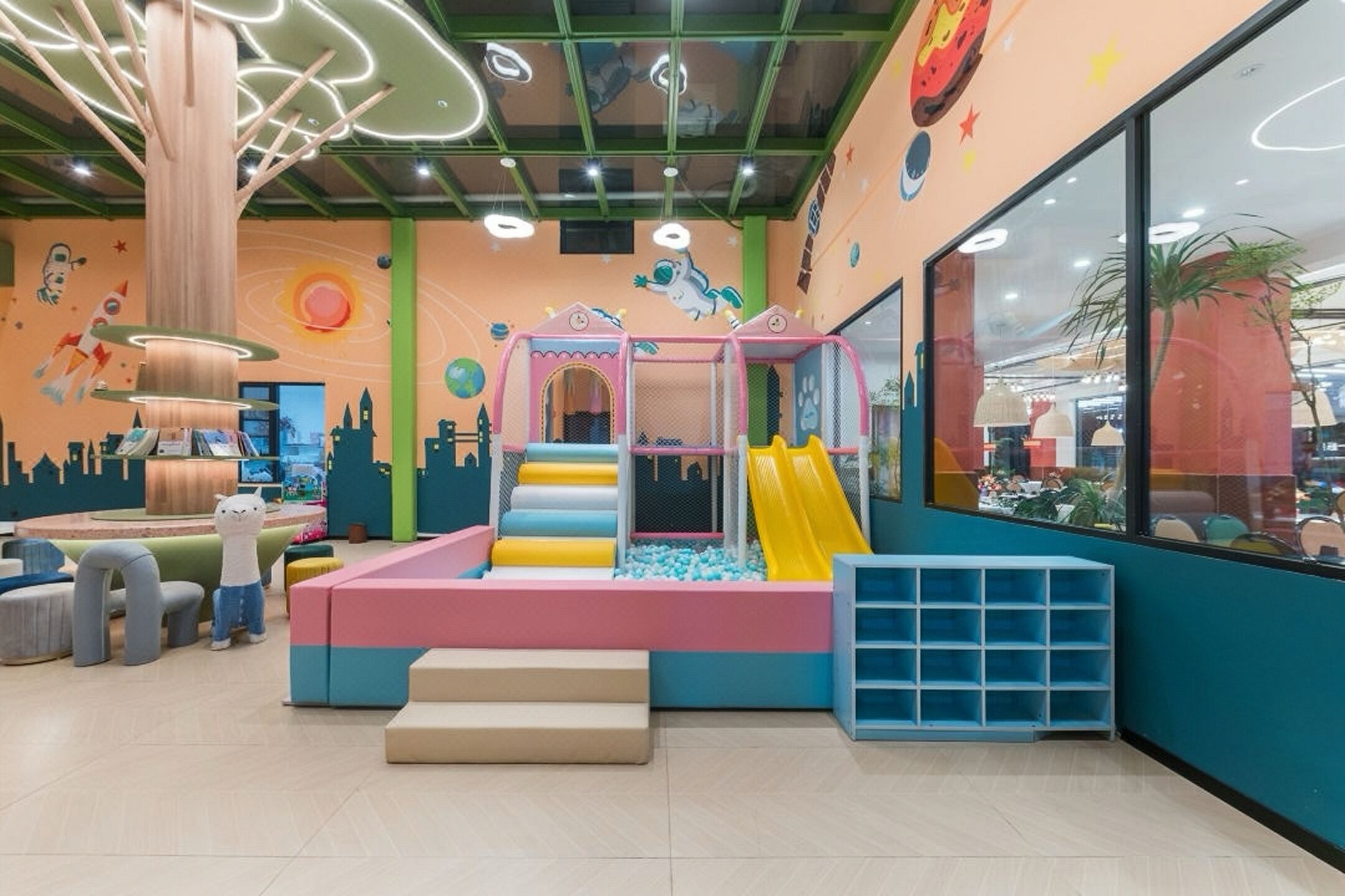 A children's play area with a slide, soft play surfaces, and a climbing structure.