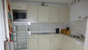 A kitchen with white cabinets, a microwave, a sink, and a dishwasher. - Bungalow for 6 People, Near the Beach (Sint Maartensvlotbrug)