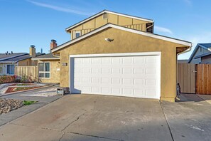 A residential house with a garage, a well-maintained driveway, and a clear sky.