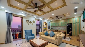 A spacious living area with a sofa, armchairs, a coffee table, and a balcony with a view. - MARCO'S INTERLUDE Hotel Phu Quoc (Phu Quoc)