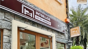 A hotel entrance with a stone facade, large glass doors, and a sign reading "INTERLUDE FOR THE WANDERLUST". - MARCO'S INTERLUDE Hotel Phu Quoc (Phu Quoc)