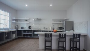 A modern kitchen with a white countertop, built-in appliances, and wooden flooring. - Modern Flat with 2 Bedrooms Near sea (Ciudad Madero)