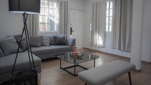 A modern living room with a grey sofa, a glass coffee table, and a floor lamp. - Modern Flat with 2 Bedrooms Near sea (Ciudad Madero)