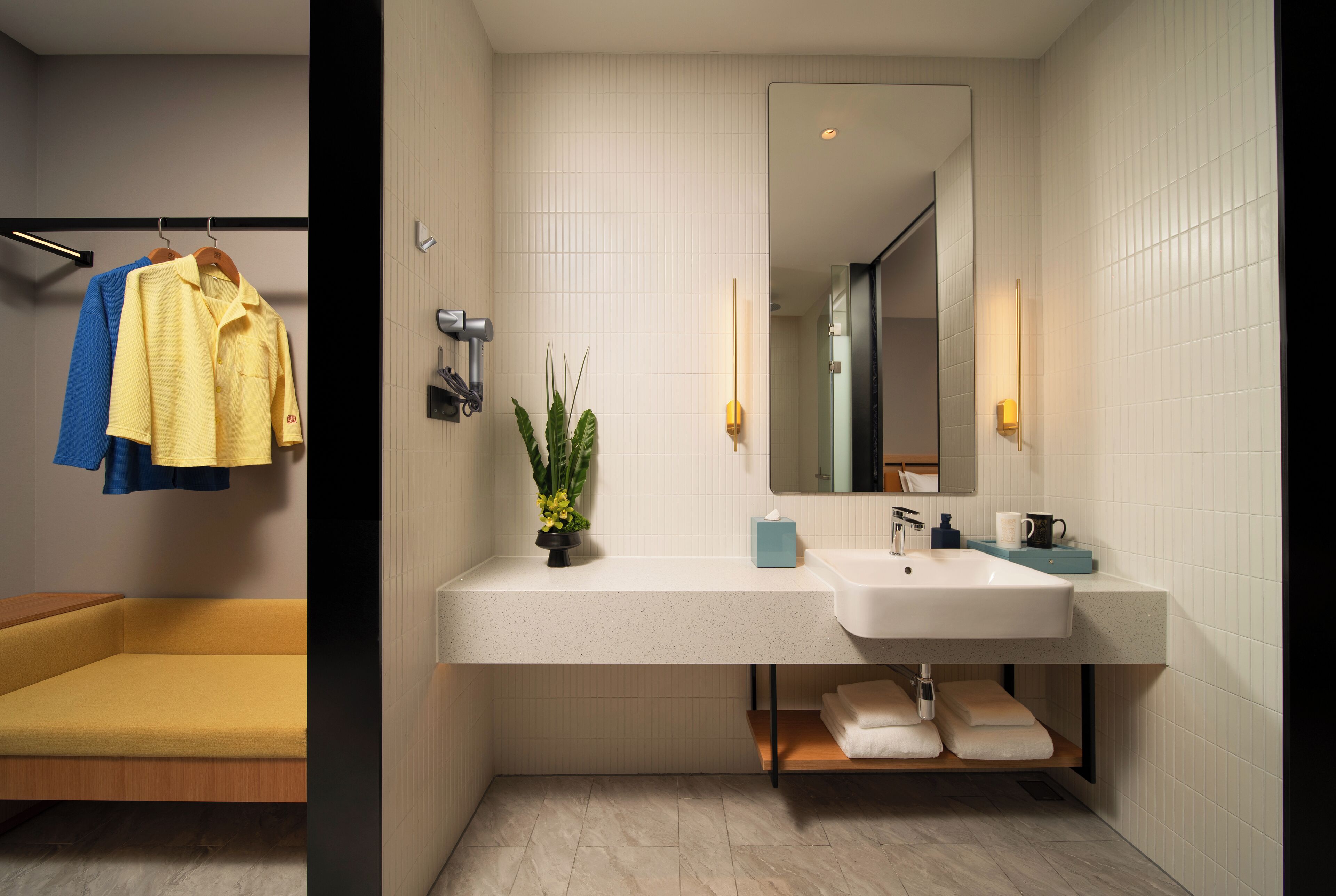 A modern bathroom with a white sink, mirror, and towel rack.