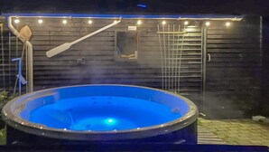 Ein Whirlpool vor einem Gebäude mit einem Metallzaun und einer Leiter.