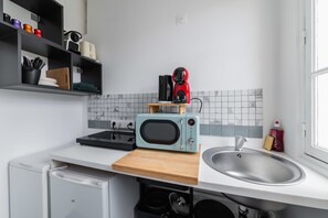 A compact kitchen with a microwave, toaster, and sink.