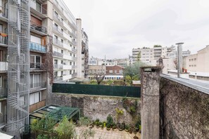 Un edificio residenziale a più piani con balconi, un tetto verde e un cortile con piante in vaso.
