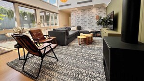 Ein modernes Wohnzimmer mit Sofa, Sesseln, Couchtisch und Kamin.