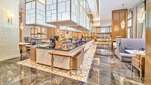 A spacious lobby with a marble floor, a central reception desk, seating areas, and a large glass partition. - TUI BLUE Taicang Hotel (Suzhou)