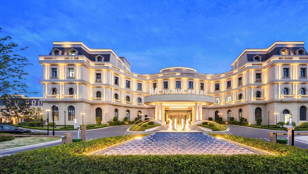 A large, multi-story hotel with a grand entrance, a central fountain, and a symmetrical facade. - TUI BLUE Taicang Hotel (Suzhou)