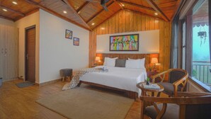 Un dormitorio amplio con una cama grande, techo de madera y un balcón con vistas.