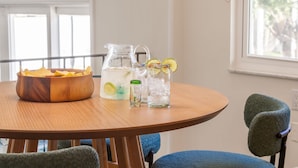 A wooden table with a bowl of chips, a pitcher of water with lime slices, and two glasses of water with ice. - 4 Minutes to Beach | Pool | Hot Tub | Game Room (Seminole)