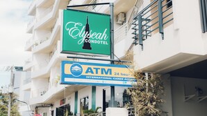 A hotel sign for Elyseah Condomotel and an ATM sign indicating 24-hour service and international card acceptance. - Elyseah Condotel Angeles Pampanga (Angeles City)