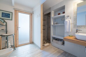 Une salle de bain moderne équipée d’une douche, de toilettes, d’un lavabo et d’un porte-serviettes.