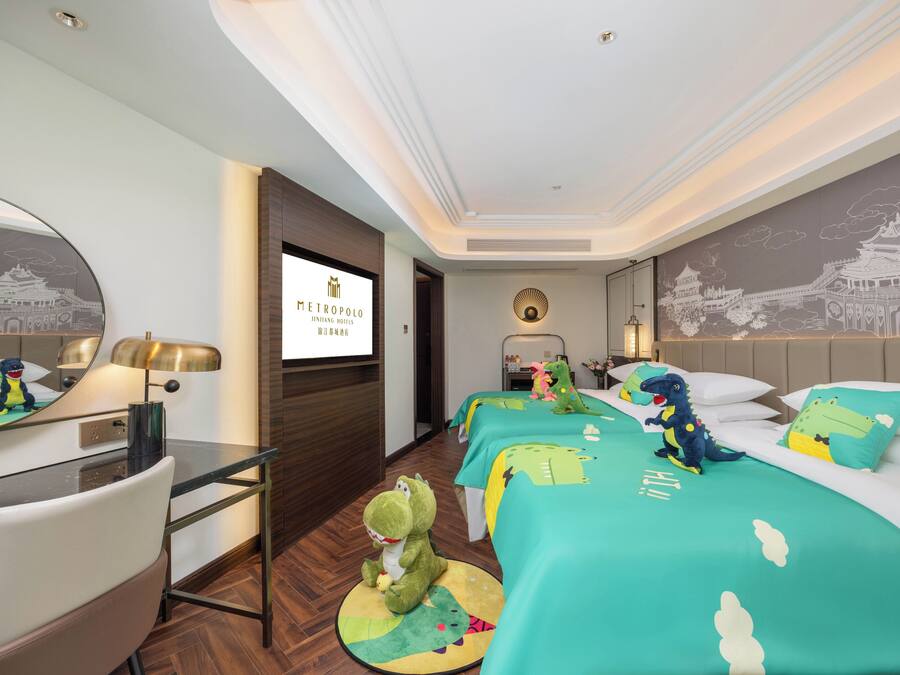 A hotel room with a bed, a desk, a chair, a mirror, and a wall with a mural.