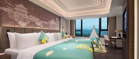 Habitación de hotel con una cama grande, un escritorio y vistas a la ciudad.