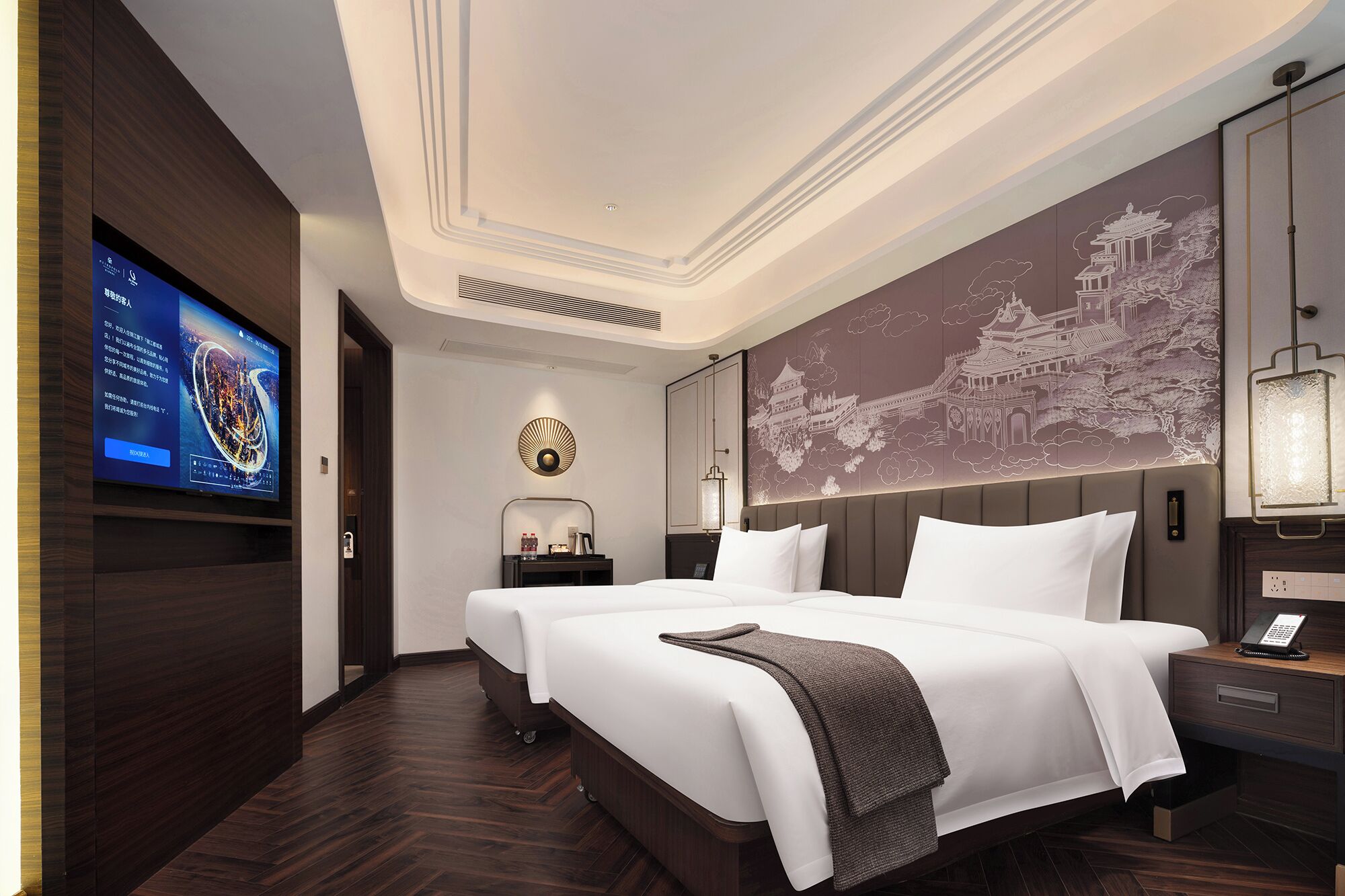 Quarto de hotel com uma cama grande, televisão na parede e um painel decorativo.