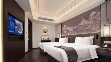 Quarto de hotel com uma cama grande, televisão na parede e um painel decorativo.