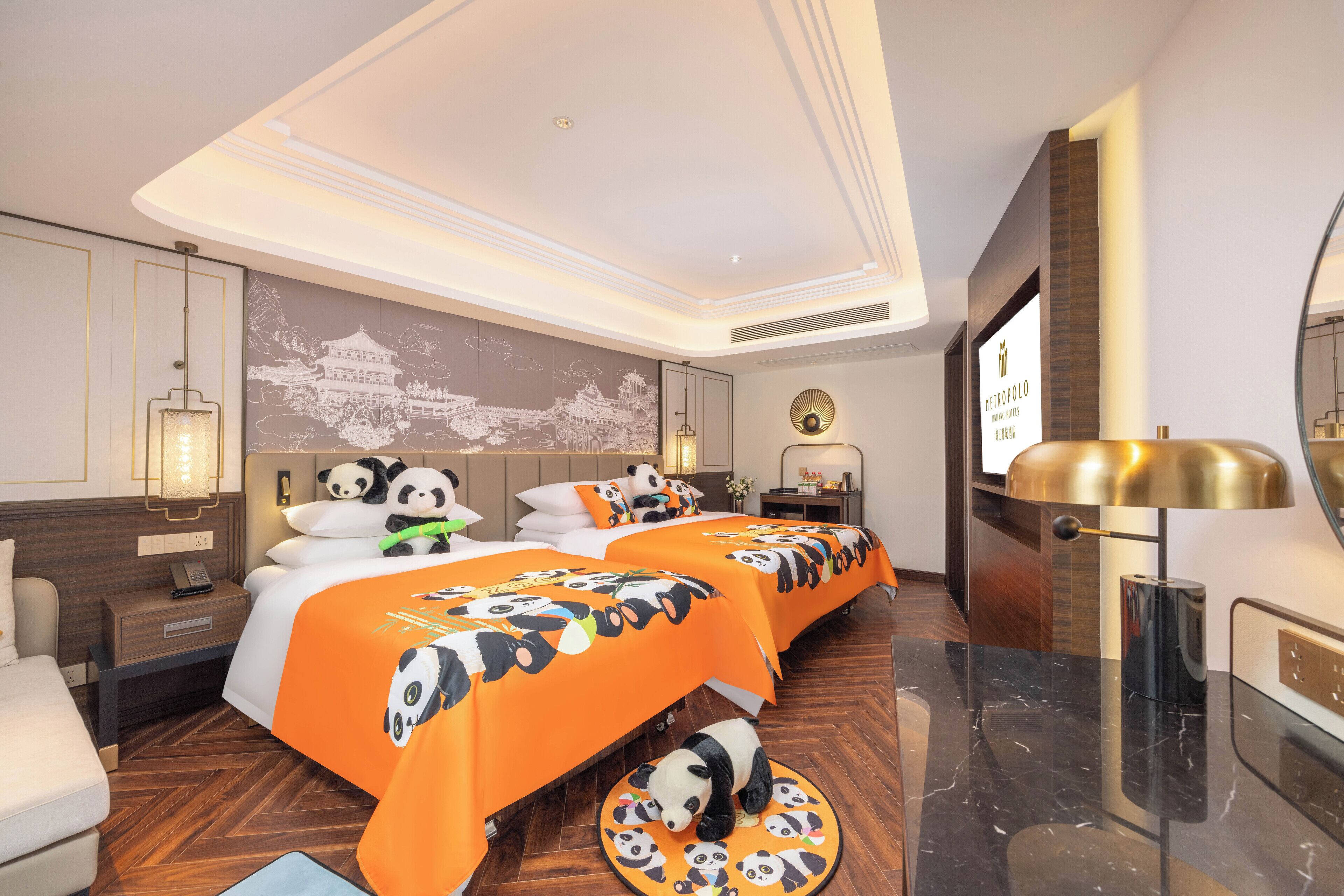 Ein Hotelzimmer mit zwei Betten, einem großen Spiegel, einer Bettdecke mit Panda-Motiv und einem Wandbild eines traditionellen Gebäudes.