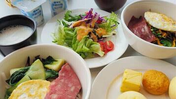 A table with various dishes including a salad, soup, and a plate with dumplings and meat.