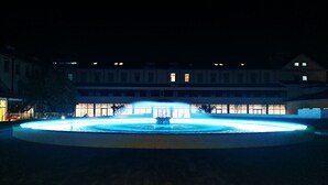 A circular fountain with a central water feature, surrounded by a paved area and a building with multiple windows in the background. - Stella Braga Aparthotel (Braga)