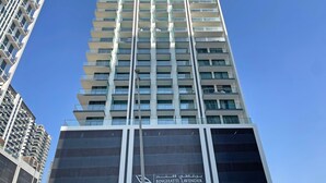 Un edificio alto con varios balcones y un cielo despejado.