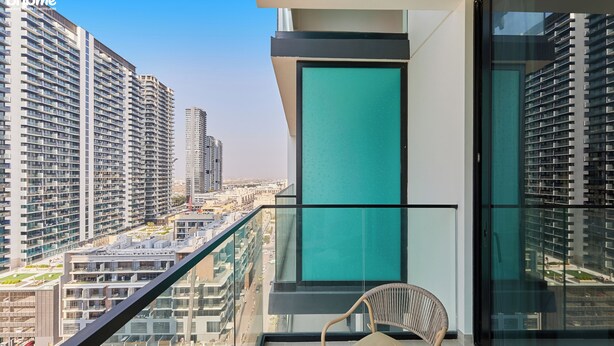 Un edificio alto con balcón que ofrece vistas a otros edificios de gran altura y una vista panorámica de la ciudad.