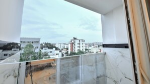 A balcony with a clear view of a cityscape, featuring modern buildings and a cloudy sky. - Namma HomeSlice (Bengaluru)