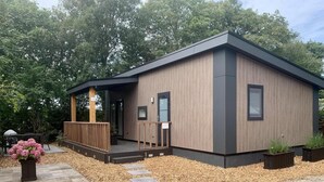 Un bâtiment moderne de plain-pied, doté d’une façade en bois et d’un toit foncé.