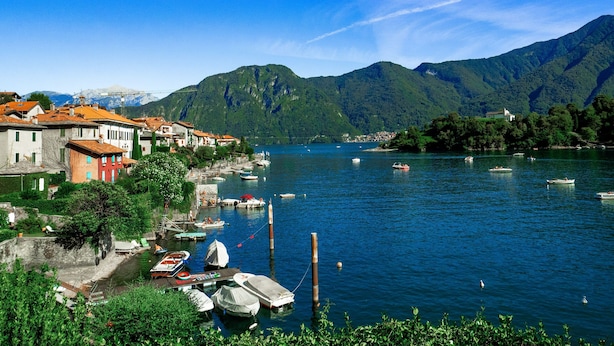 A lakeside town with boats docked along the shore, surrounded by mountains. - Casa Caterina in Tremezzo (Tremezzina)