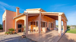 A Mediterranean-style house with a covered patio, outdoor seating, and a barbecue area. - Son Morro Ca Na Poveta (Santa Margalida)