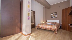 A bedroom with a bed, wardrobe, and a door leading to another room. - Fontana Del Lago Apt 7 (Varenna)
