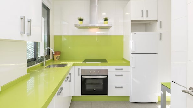 A modern kitchen with white cabinets, a green countertop, a built-in oven, and a white refrigerator. - La Ronda C diz in Jerez de la Frontera (Jerez de la Frontera)
