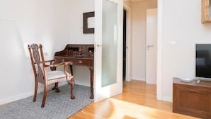 A room with a wooden desk, a chair, a television, and a door leading to another room. - La Ronda C diz in Jerez de la Frontera (Jerez de la Frontera)