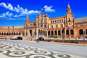 A historic building with a large central courtyard, arched walkways, and a prominent tower. - Divina in Sevilla With 1 Bedrooms and 1 Bathrooms (Seville)