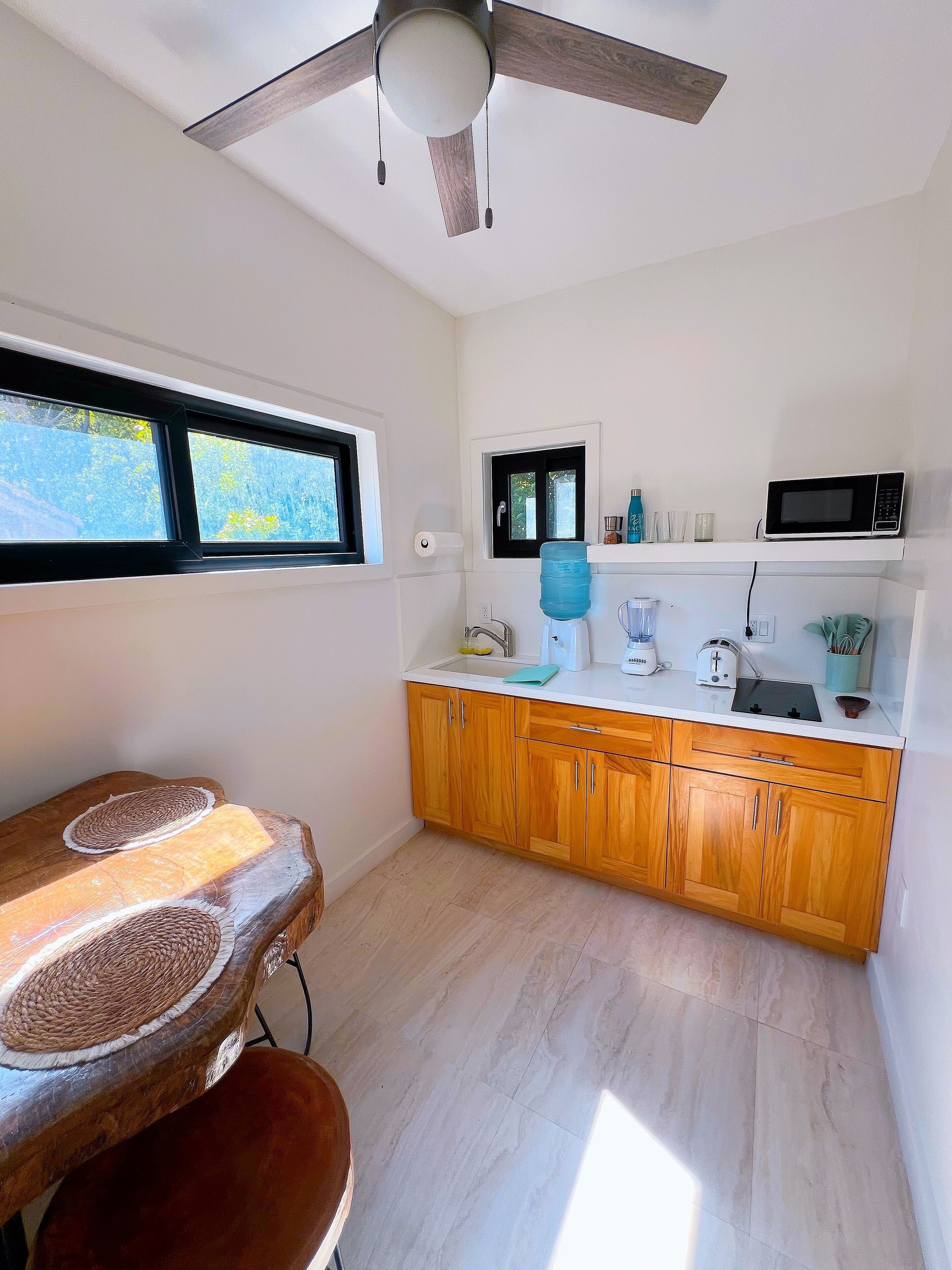 A kitchen with wooden cabinets, a microwave, and a water dispenser.