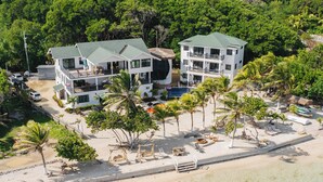 A beachfront hotel with multiple buildings, a pool, and palm trees. - Curacion Beach Resort (Brick Bay)