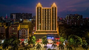 Un hôtel de grande hauteur au design moderne, caractérisé par des lignes verticales et une entrée imposante.