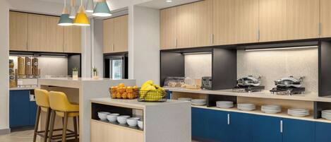 A modern kitchen with wooden cabinets, a central island with stools, and a variety of kitchen appliances and utensils.