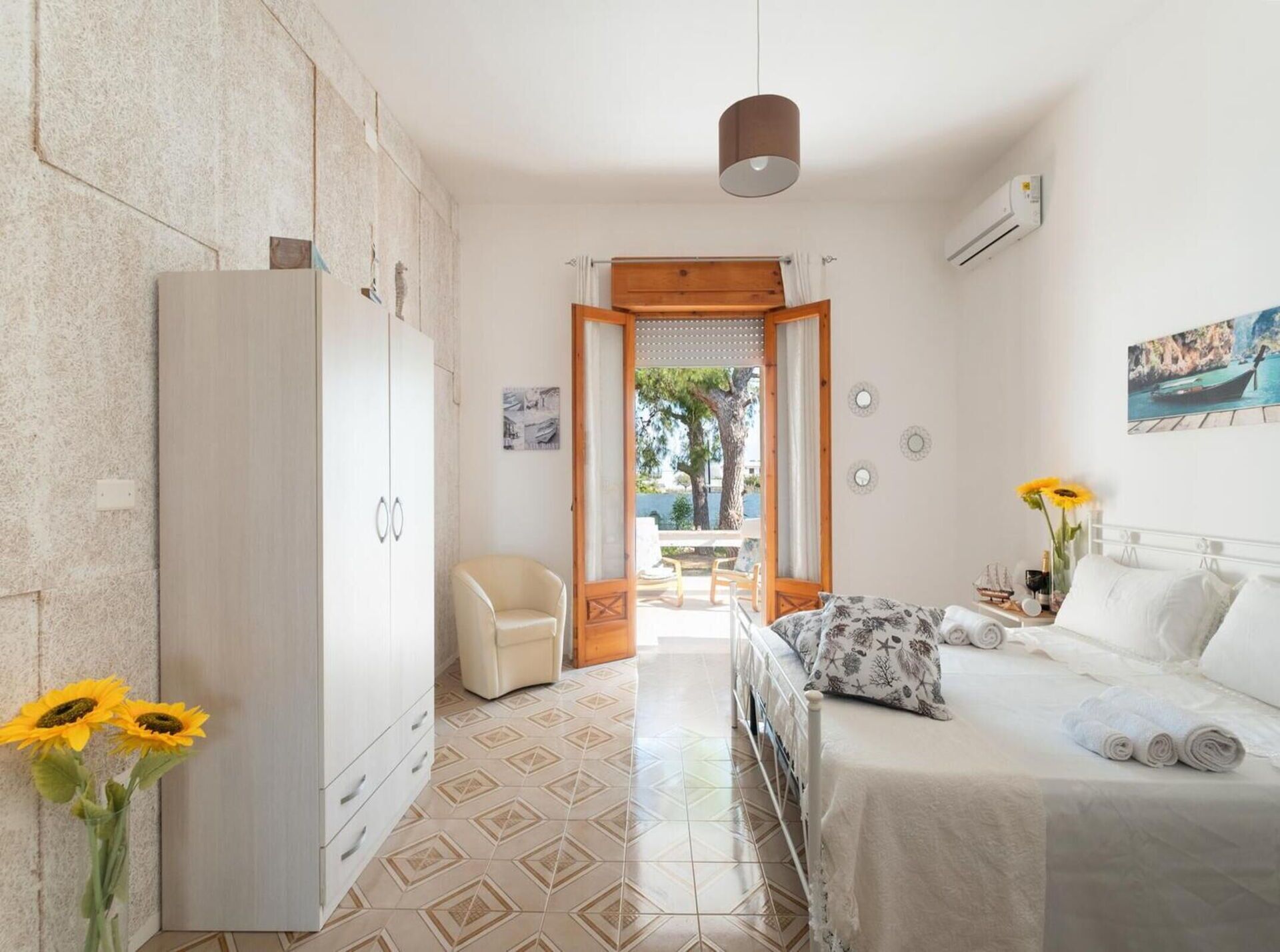 Une chambre à coucher avec un lit, une armoire, une chaise et une vue sur l’extérieur.