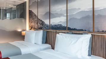 A hotel room with a large bed, a wooden headboard, and a mountain view mural.
