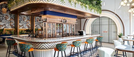 A bar area with a curved counter, bar stools, and a patterned floor.