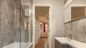 A modern bathroom with a glass-enclosed shower, a white sink, and a large mirror. - Ash Tree Lodge - sleeps 4 guests in 2 bedrooms (Appin)