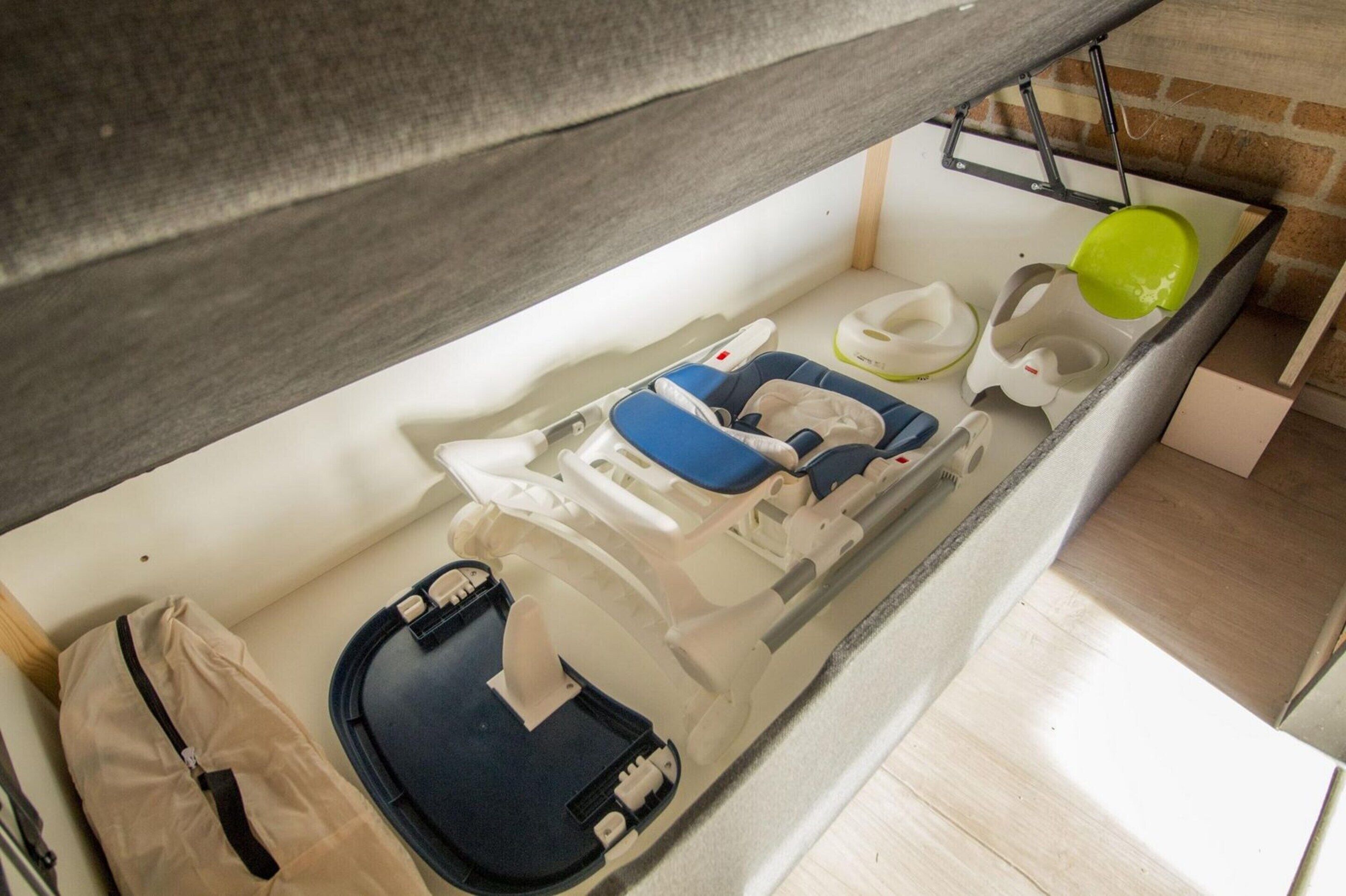 A compact, modern room with a built-in bed, a small seating area, and a sink.