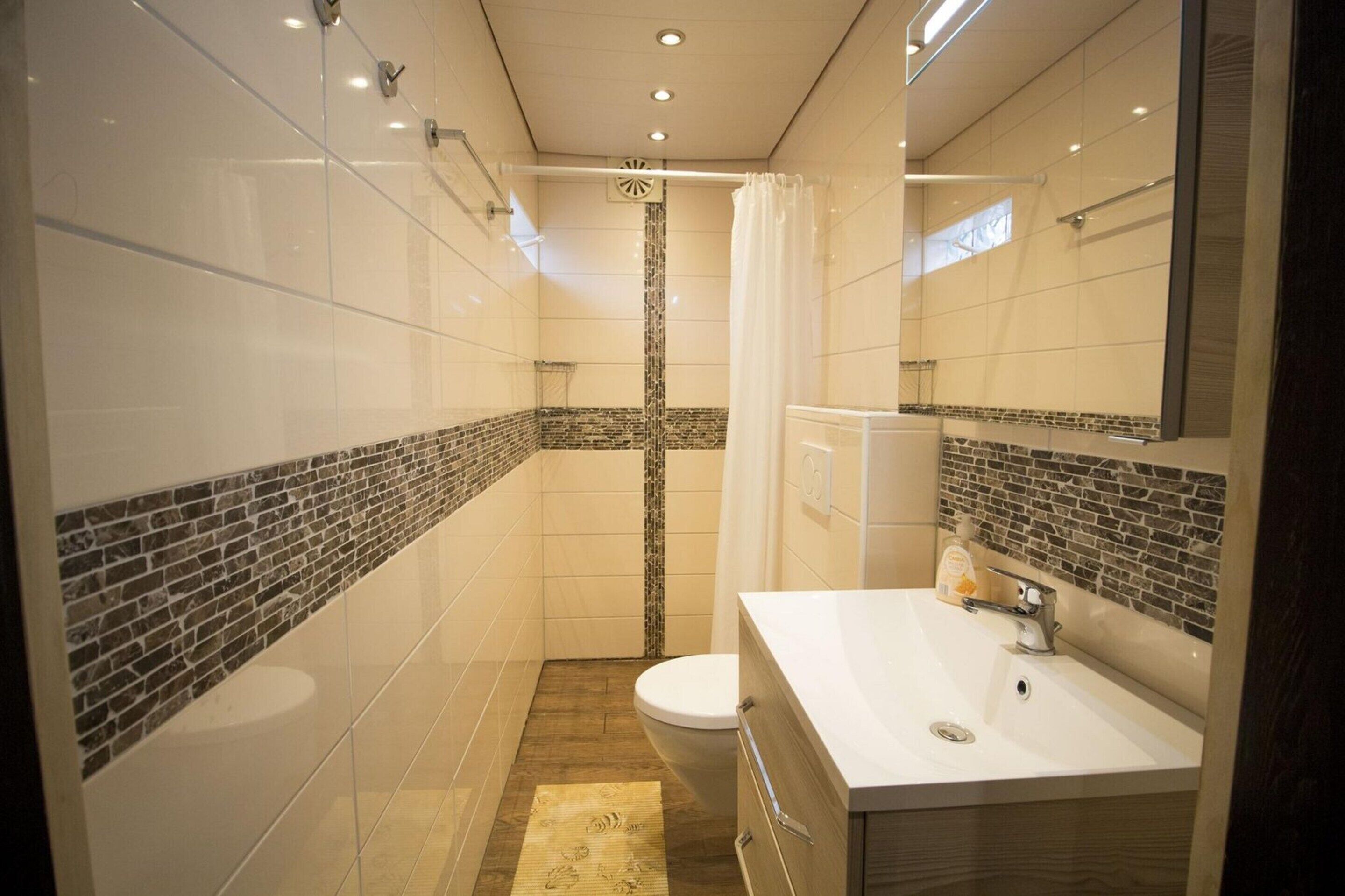 Ein modernes Badezimmer mit Dusche, Toilette und Waschbecken.
