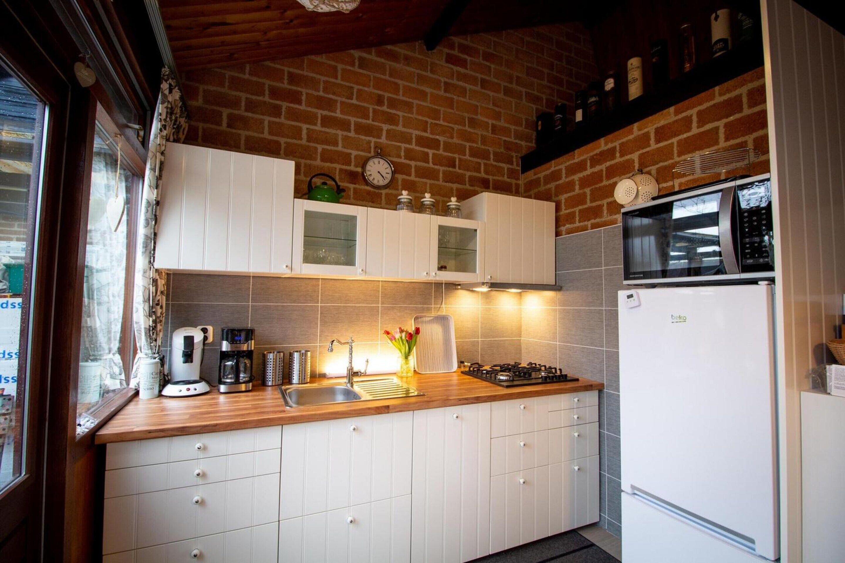 A kitchen with white cabinets, a microwave, a coffee maker, and a gas stove.