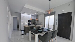 A modern kitchen with a dining area, featuring a marble floor, contemporary furniture, and pendant lighting. - 10min from the beach, Villa 2023 with Swimming Pool, Terrace, Roof-Terrace, Parking  (Orihuela)