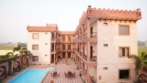 A hotel with a pool, outdoor seating, and a courtyard. - HOTEL THE FORT (Amroha)